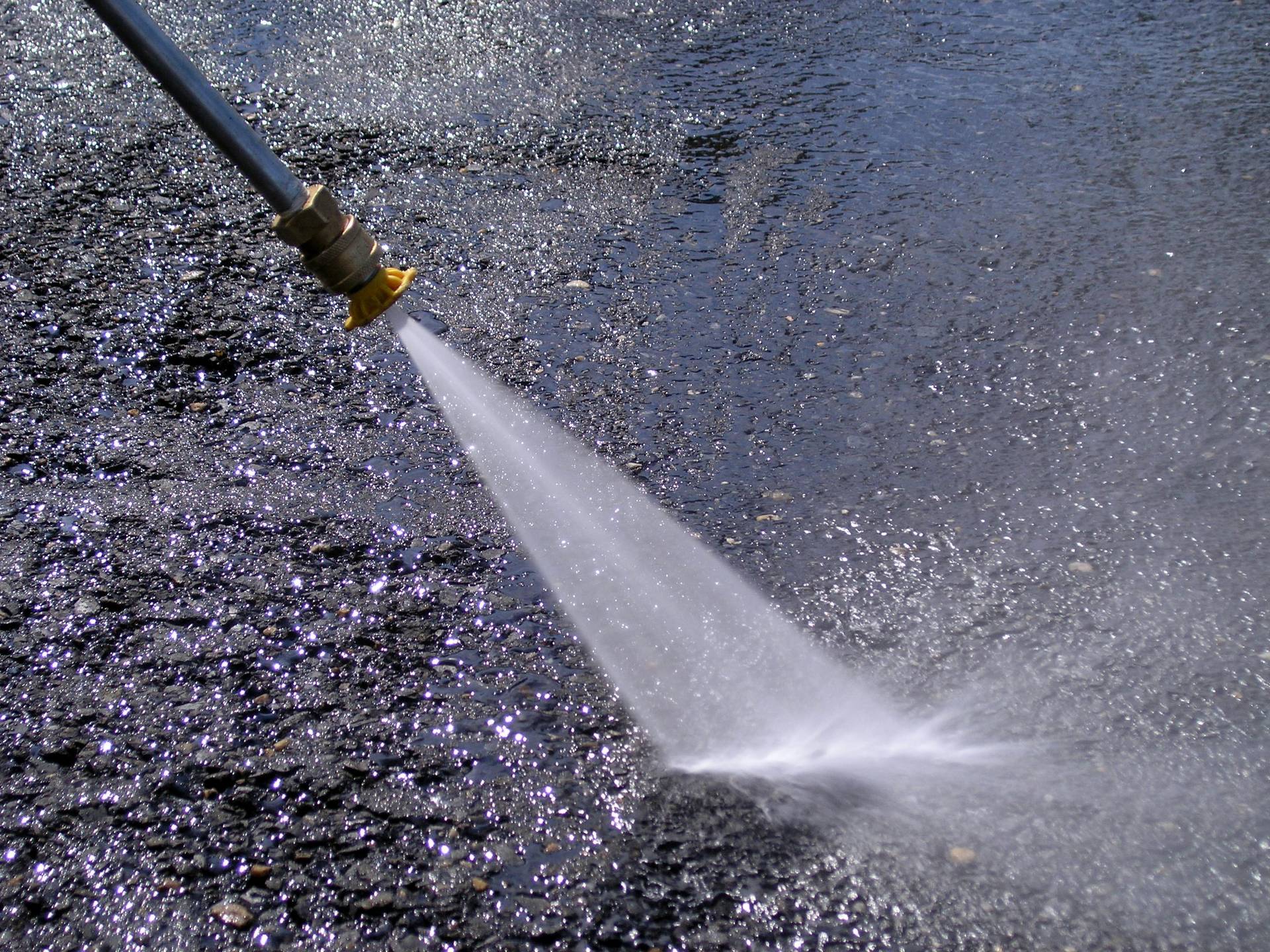 Pressure washing nozzle cleaning pavement