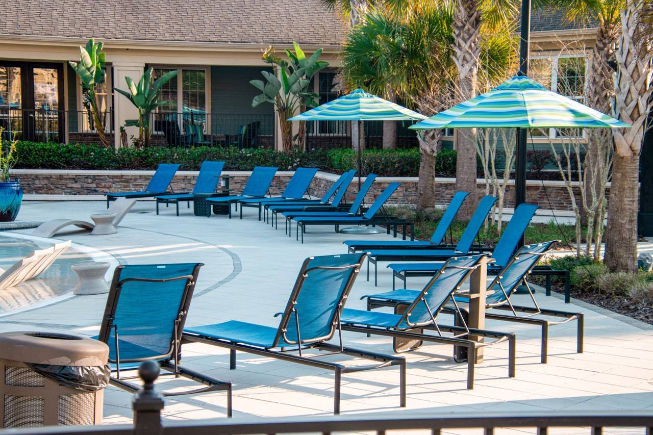 Resort-style pool deck with lounge chairs and umbrellas